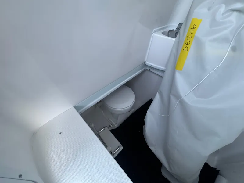 Slide: The Image of Interior of 2025 Contender 39ST boat featuring a compact marine toilet area. - 5