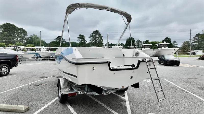 Slide: The Image of 2025 Starcraft SVX 171 OB boat on trailer, parked in a lot with overcast sky. - 2