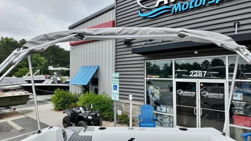 Slide: The Image of 2025 Starcraft SVX 171 OB boat displayed outside dealership with canopy and showroom in background. - 5