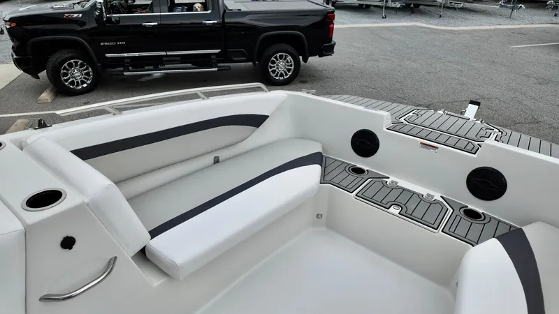 Slide: The Image of 2025 Starcraft SVX 171 OB boat interior with seating and storage, parked near a black truck. - 8