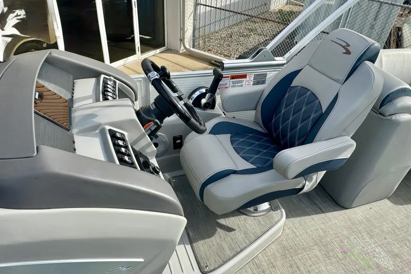 Slide: The Image of Captain's seat and helm of 2023 Bennington 24 LXFB pontoon boat, featuring modern controls. - 23