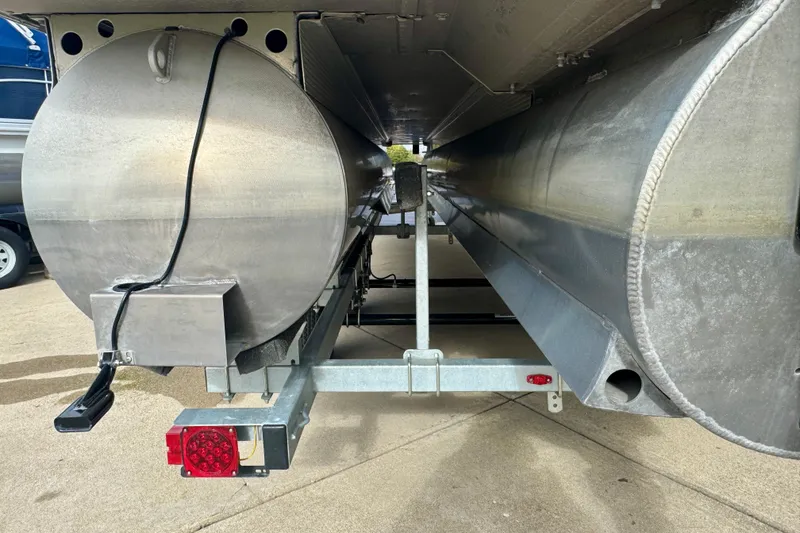 Slide: The Image of Underneath view of 2023 Bennington 24 LXFB pontoon boat, showcasing aluminum pontoons and trailer. - 31