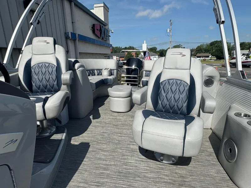 Slide: The Image of 2023 Bennington 24 LXFB pontoon boat on trailer, under cloudy sky. - 7