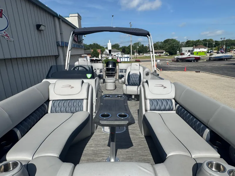 Slide: The Image of 2023 Bennington 24 LXFB pontoon boat on trailer under cloudy sky. - 9