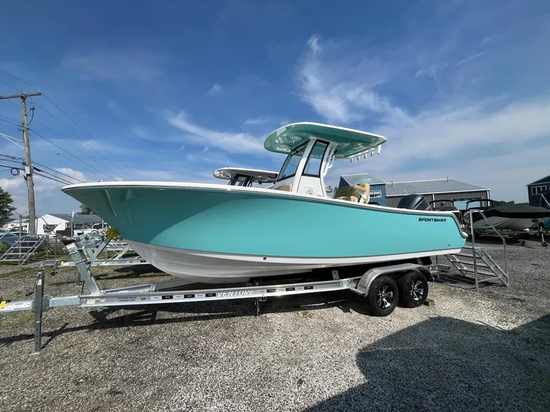 The Image of 2025 Sportsman Open 232 Center Console boat on trailer, under clear blue sky. - 1