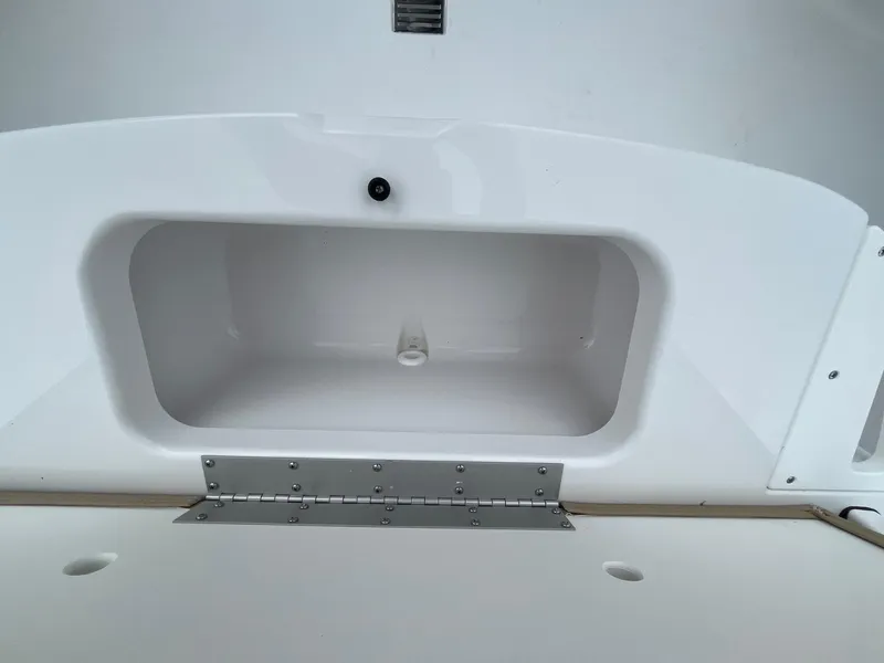 Slide: The Image of 2025 Sportsman Open 232 Center Console storage compartment, white interior, open lid. - 12