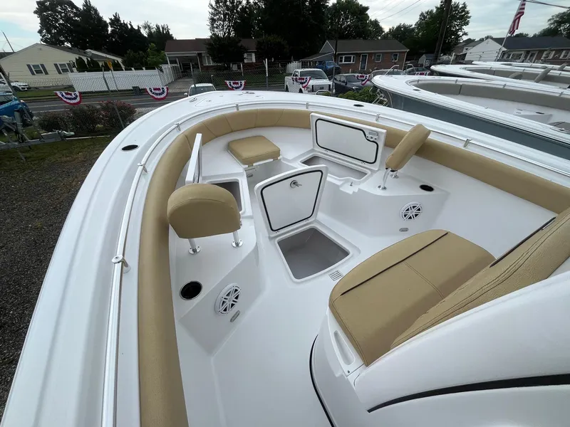 Slide: The Image of 2025 Sportsman Open 232 Center Console boat interior with tan seating and storage compartments. - 13