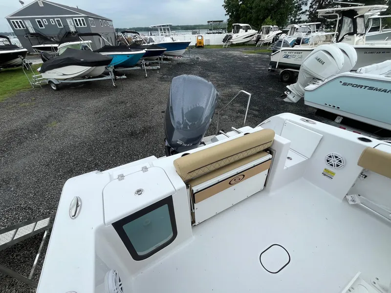 Slide: The Image of 2025 Sportsman Open 232 Center Console boat in a marina with other vessels. - 5