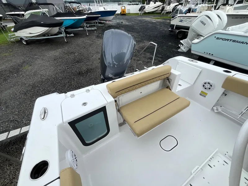 Slide: The Image of 2025 Sportsman Open 232 Center Console boat interior with seating and motor, in a marina. - 6