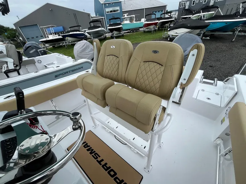 Slide: The Image of 2025 Sportsman Open 232 Center Console boat with tan cushioned seating and steering wheel. - 8