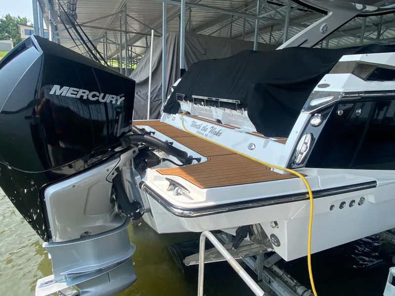 Slide: The Image of 2022 Monterey 385 Super Sport boat with Mercury engine, docked under a canopy. - 15