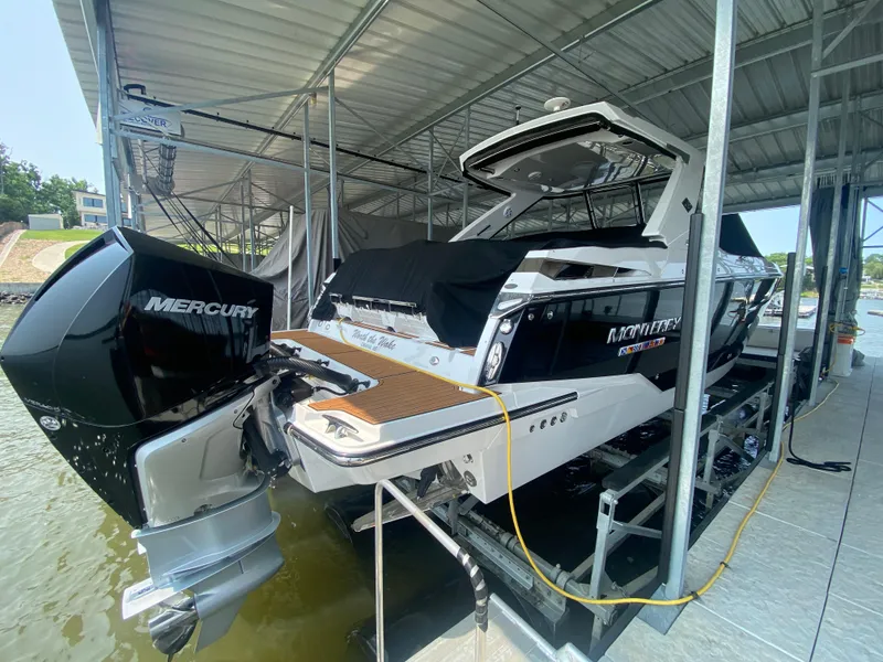 Slide: The Image of 2022 Monterey 385 Super Sport boat docked with Mercury outboard engine. - 16