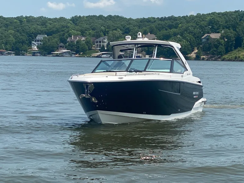 Slide: The Image of 2022 Monterey 385 Super Sport boat cruising on a lake with scenic background. - 2