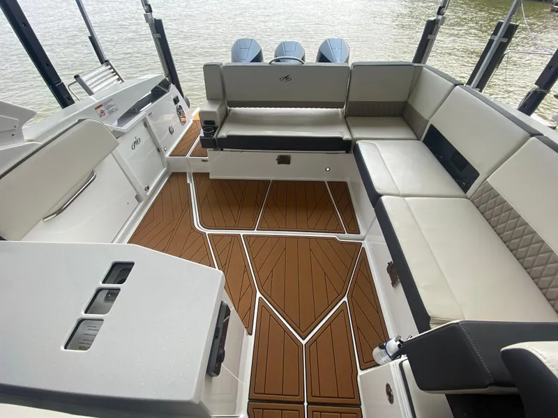 Slide: The Image of 2022 Monterey 385 Super Sport boat interior with spacious seating and elegant wood flooring. - 21