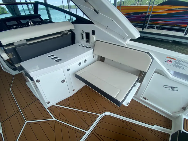 Slide: The Image of 2022 Monterey 385 Super Sport interior with white seating and wood-patterned flooring. - 23