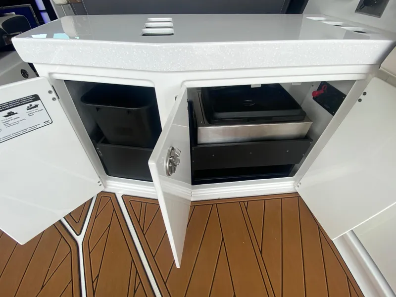 Slide: The Image of Open storage compartments on a 2022 Monterey 385 Super Sport boat with teak flooring. - 24