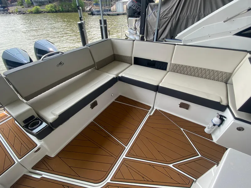Slide: The Image of 2022 Monterey 385 Super Sport boat interior with cushioned seating and wooden flooring. - 25