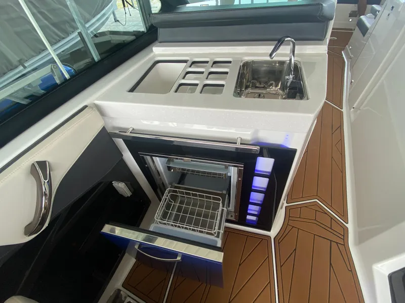 Slide: The Image of 2022 Monterey 385 Super Sport boat interior with sink, stove, and open drawer. - 32