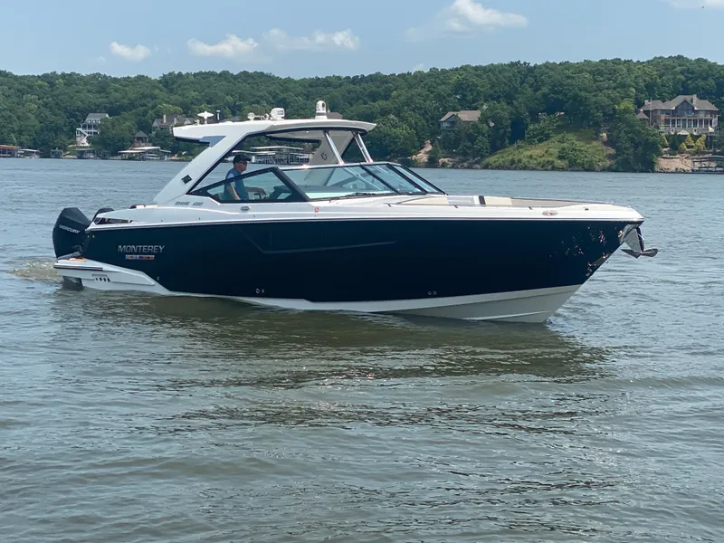Slide: The Image of 2022 Monterey 385 Super Sport boat cruising on a lake with scenic background. - 4