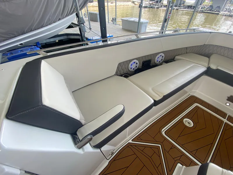Slide: The Image of 2022 Monterey 385 Super Sport boat interior with cushioned seating and wood-patterned flooring. - 43