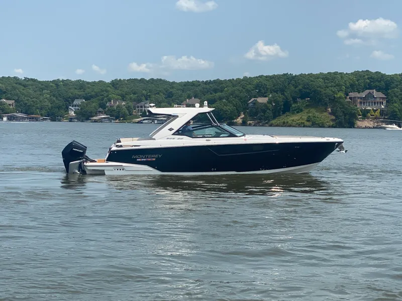 Slide: The Image of 2022 Monterey 385 Super Sport boat on a lake with scenic background. - 7