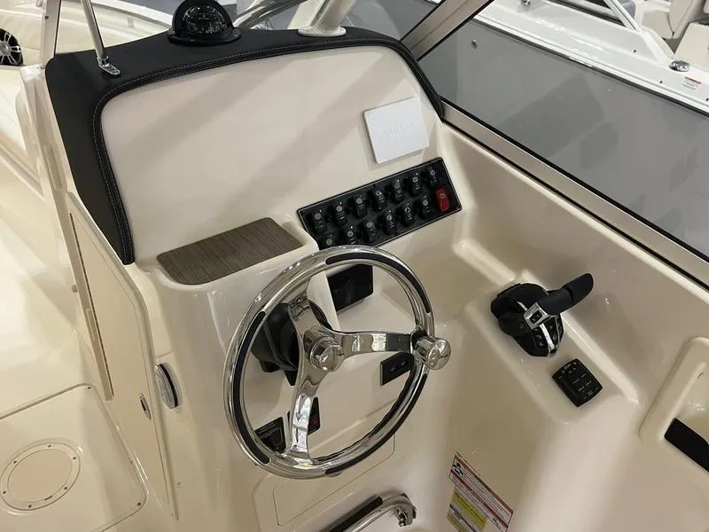 Slide: The Image of 2025 Grady-White Freedom 255 boat helm with steering wheel and control panel. - 8