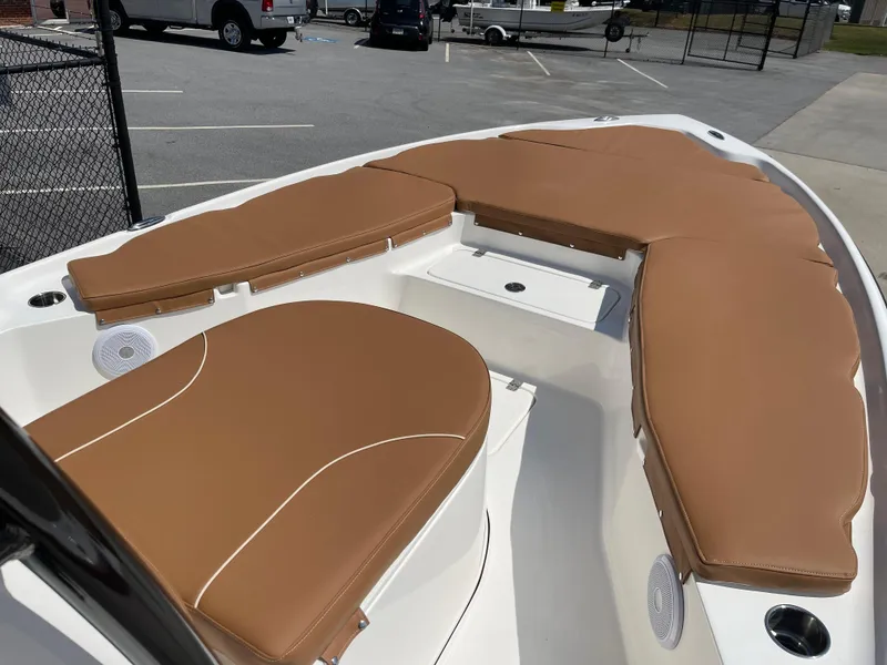 Slide: The Image of 2025 Key West 250BR boat with tan cushioned seating and storage compartment. - 11
