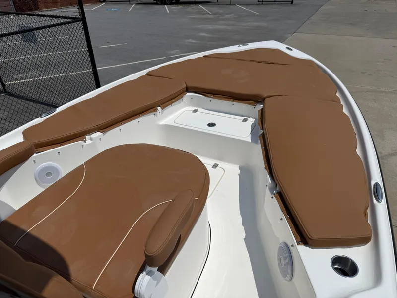 Slide: The Image of 2025 Key West 250BR boat with tan cushioned seating in a parking lot. - 15