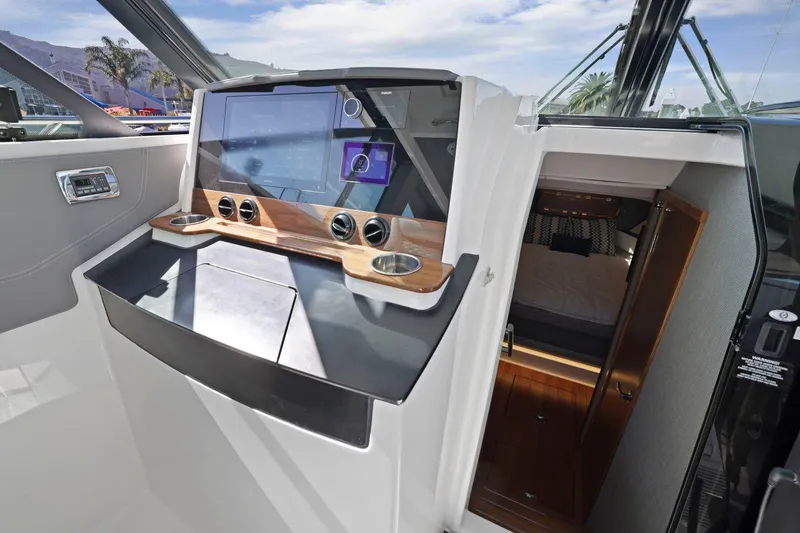 Slide: The Image of 2022 Tiara Yachts 43 LE helm with modern navigation system and cabin entrance. - 26