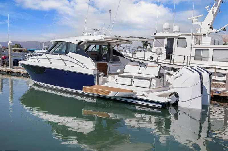 Slide: The Image of 2022 Tiara Yachts 43 LE docked, showcasing sleek design and powerful outboard engines. - 7