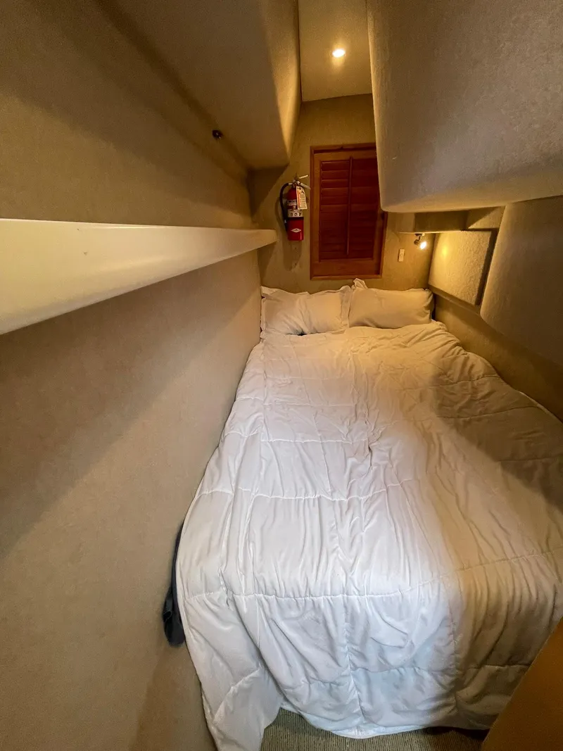 Slide: The Image of Cozy cabin bedroom in 1997 Roger Hill 11.2m Powercat with white bedding. - 12