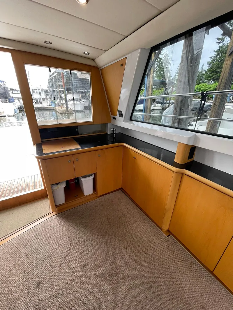 Slide: The Image of Interior of 1997 Roger Hill 11.2m Powercat with wooden cabinetry and large windows. - 17