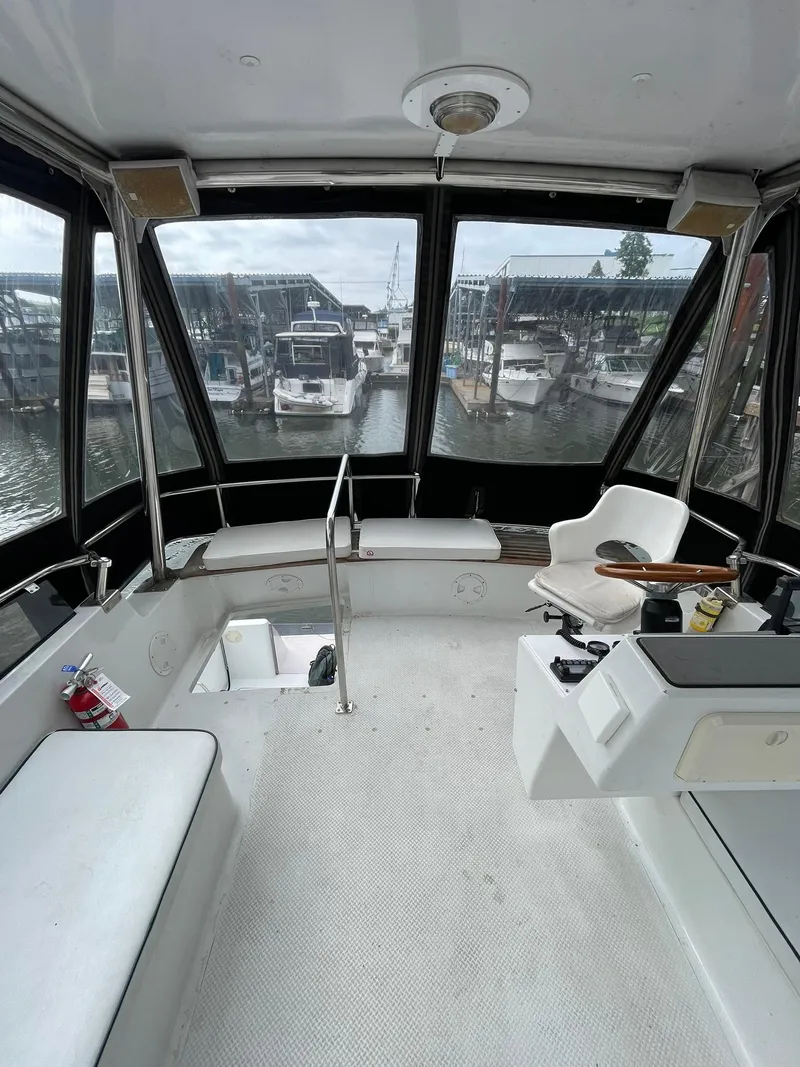 Slide: The Image of 1997 Roger Hill 11.2m Powercat interior with marina view, featuring helm and seating area. - 28