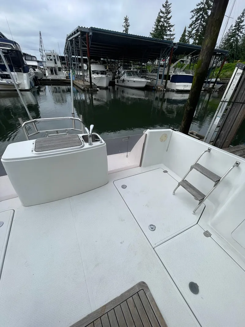 Slide: The Image of 1997 Roger Hill 11.2m Powercat docked, featuring spacious deck and marina backdrop. - 36