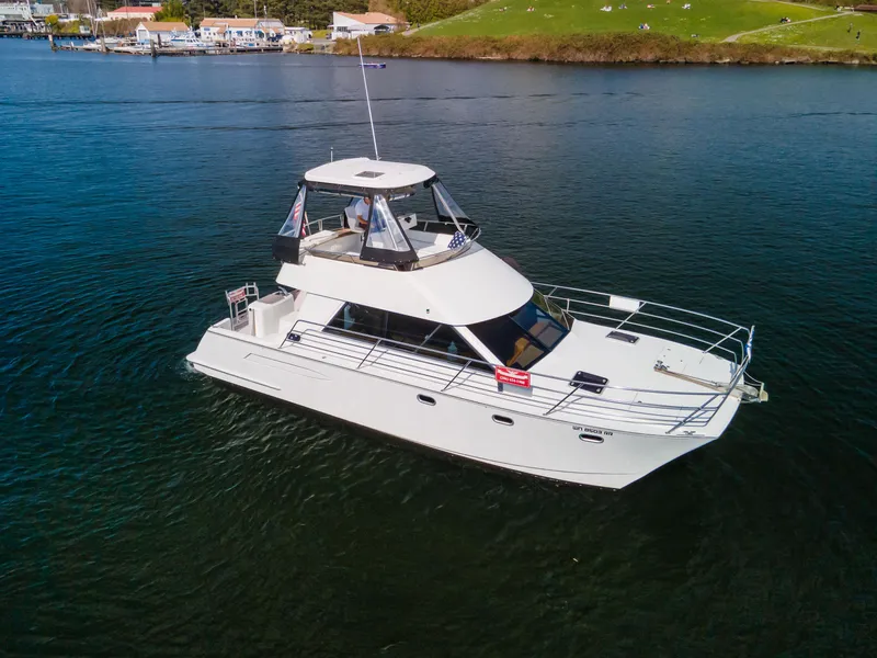 Slide: The Image of 1997 Roger Hill 11.2m Powercat on calm water, showcasing sleek design and spacious deck. - 40