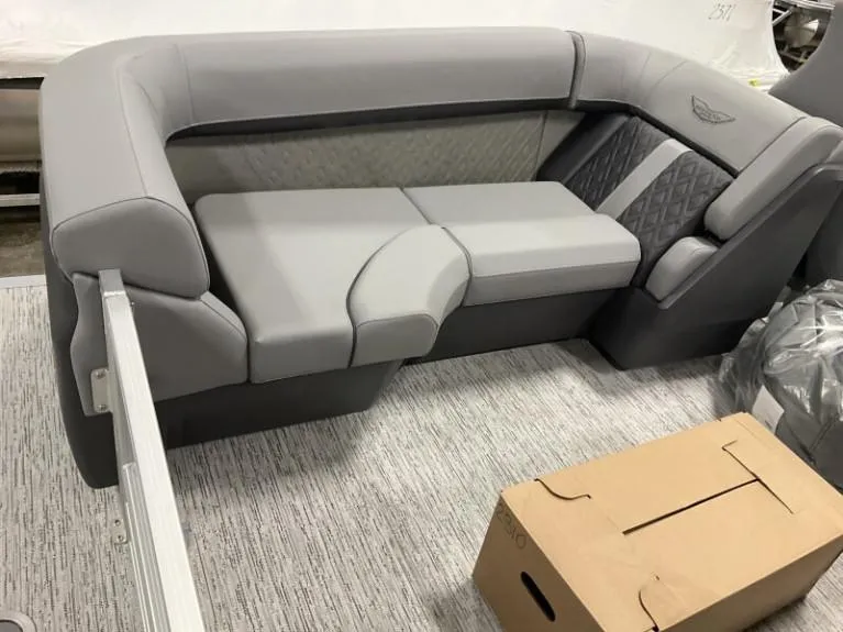 Slide: The Image of 2025 Bennington 22 MFB boat interior with gray seating and a cardboard box. - 3