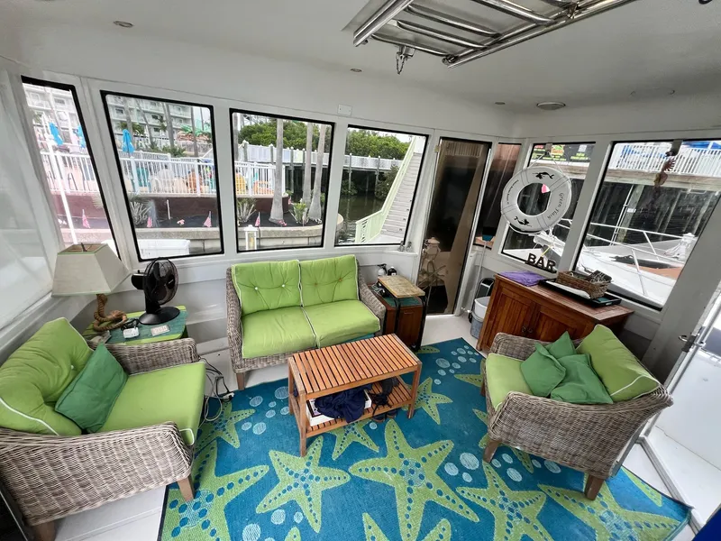 Slide: The Image of Interior of 2000 Carver 506 Motor Yacht with green seating and starfish-patterned rug. - 10