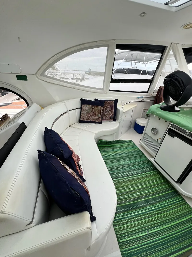 Slide: The Image of Interior of 2000 Carver 506 Motor Yacht with white seating and green rug. - 12