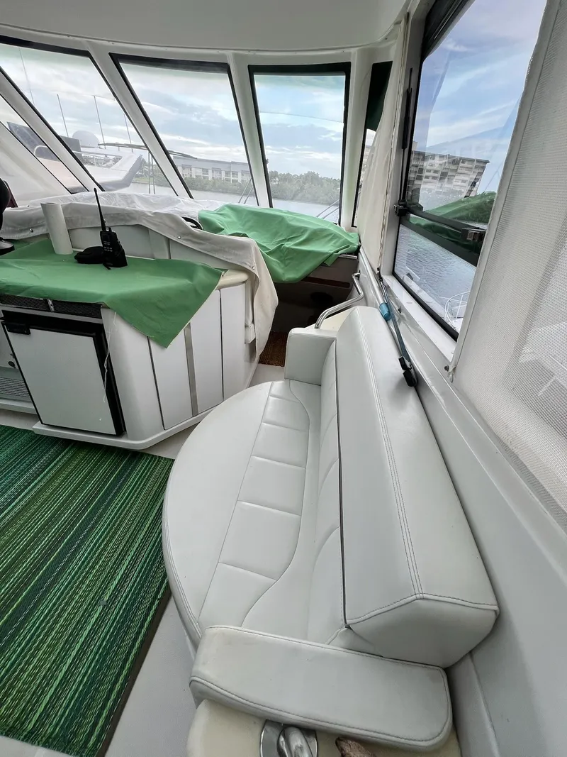 Slide: The Image of Interior of 2000 Carver 506 Motor Yacht with white seating and green accents. - 13