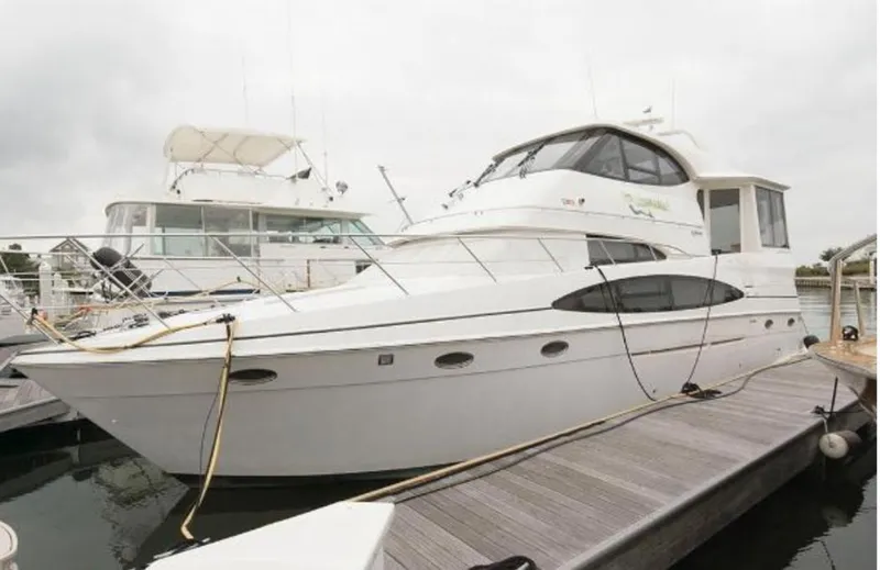 The Image of 2000 Carver 506 Motor Yacht docked at marina, showcasing sleek design and spacious deck. - 0