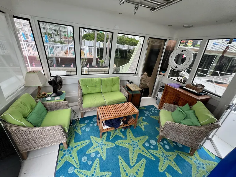 Slide: The Image of Interior of 2000 Carver 506 Motor Yacht with green seating and starfish-patterned rug. - 11