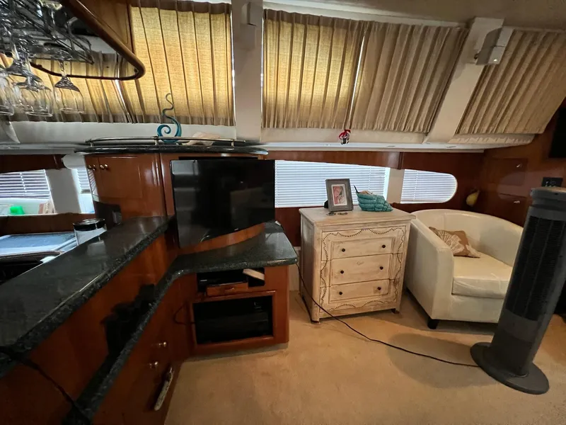 Slide: The Image of Interior of 2000 Carver 506 Motor Yacht with TV, cabinet, and seating area. - 16