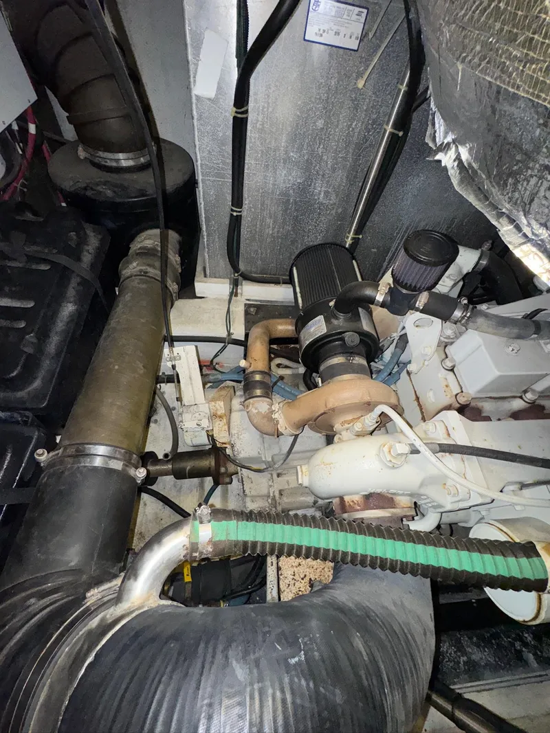 Slide: The Image of Engine room of a 2000 Carver 506 Motor Yacht, showcasing mechanical components and piping. - 23