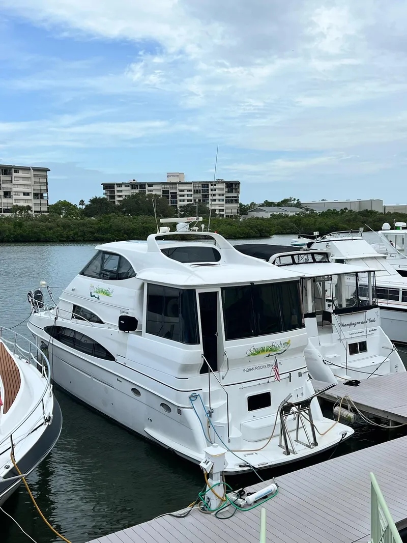 Slide: The Image of 2000 Carver 506 Motor Yacht docked at marina with buildings in background. - 3