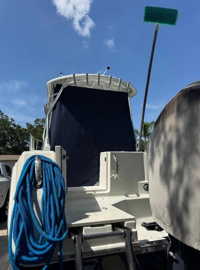 Slide: The Image of 2008 Sailfish 30-06 Express boat with blue rope and cleaning brush, under clear sky. - 10