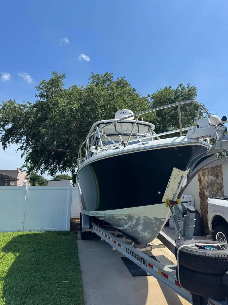 Slide: The Image of 2008 Sailfish 30-06 Express boat on trailer, parked outdoors under clear blue sky. - 11