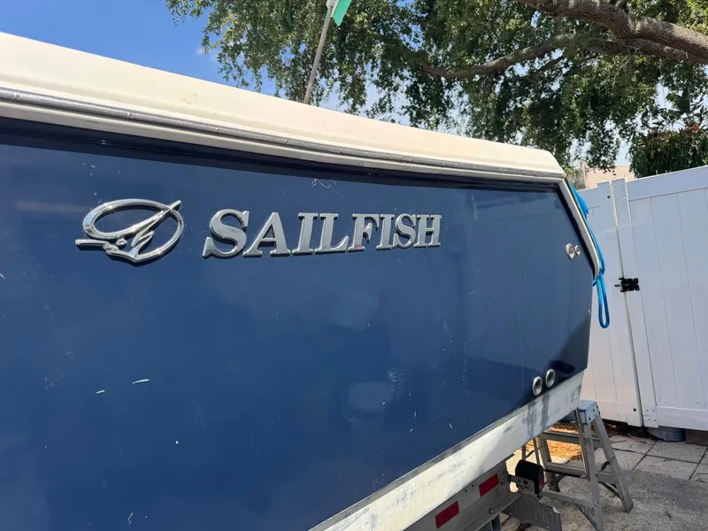 Slide: The Image of Blue 2008 Sailfish 30-06 Express boat with logo, parked outdoors. - 3