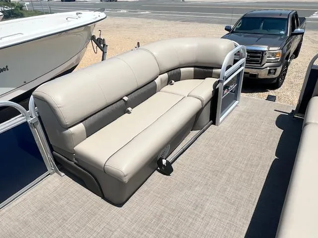 Slide: The Image of 2021 Sun Tracker Party Barge 20 DLX with beige seating, parked near a truck. - 10