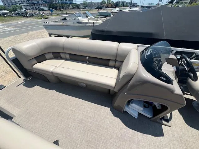Slide: The Image of 2021 Sun Tracker Party Barge 20 DLX with beige seating and helm, docked at marina. - 11