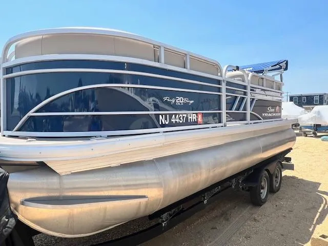 Slide: The Image of 2021 Sun Tracker Party Barge 20 DLX pontoon boat on trailer, side view. - 2